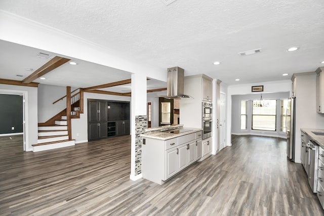 kitchen with a textured ceiling, stainless steel appliances, island range hood, beam ceiling, and dark hardwood / wood-style floors