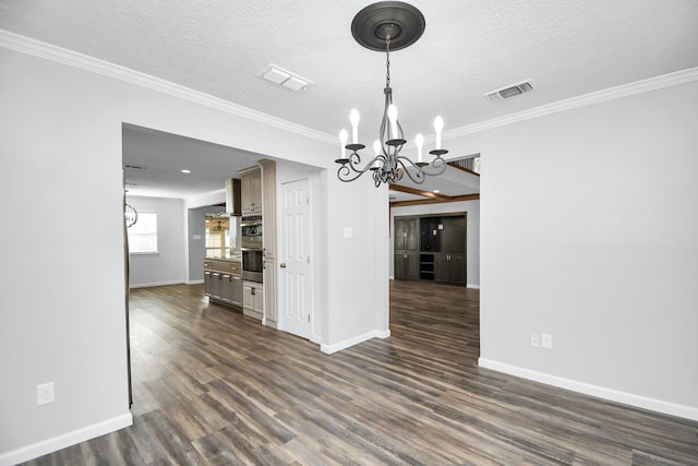 unfurnished dining area with a textured ceiling, ornamental molding, dark wood-type flooring, and a chandelier