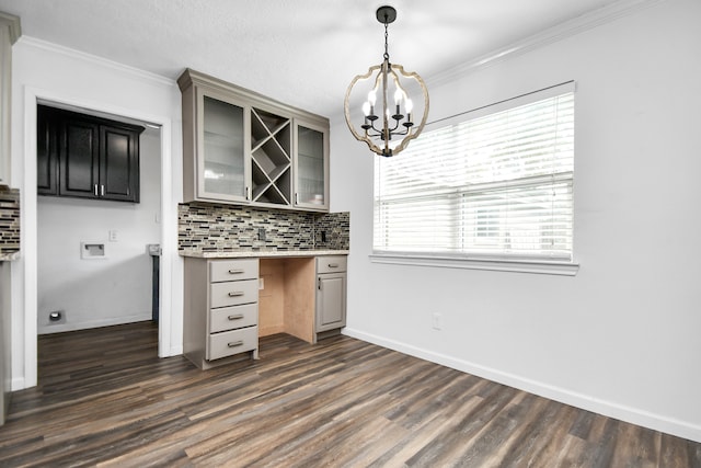 kitchen with backsplash, ornamental molding, pendant lighting, an inviting chandelier, and dark hardwood / wood-style floors