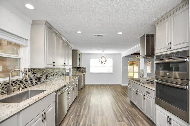 kitchen featuring sink, hanging light fixtures, dark wood-type flooring, backsplash, and appliances with stainless steel finishes