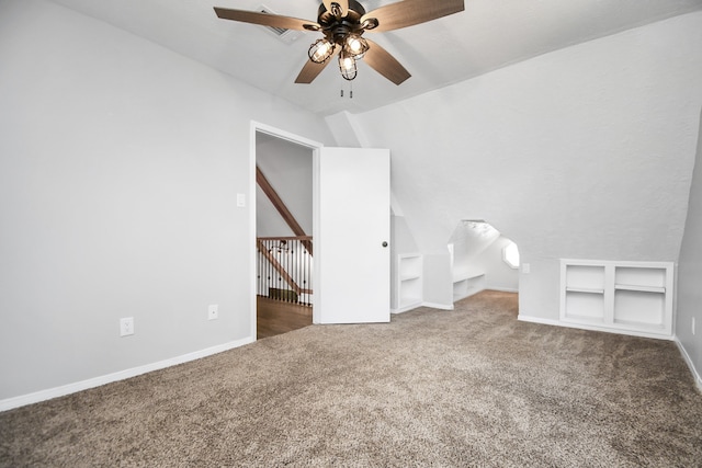 interior space featuring ceiling fan, dark carpet, and lofted ceiling