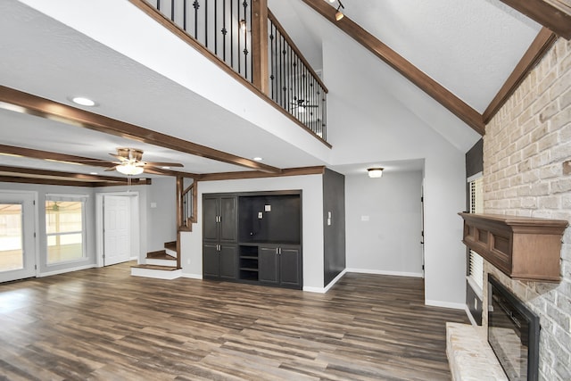 unfurnished living room featuring a textured ceiling, dark hardwood / wood-style floors, a brick fireplace, and ceiling fan