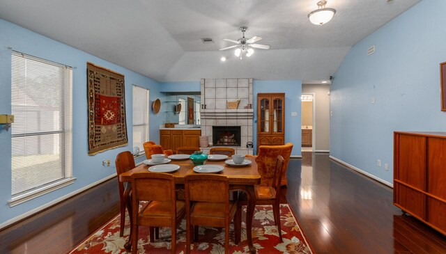 16418 Red Oak Dr, Missouri City, TX 77489 - dining area featuring ceiling fan, dark hardwood / wood-style flooring, a tiled fireplace, a textured ceiling, and lofted ceiling