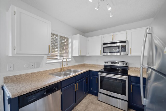 kitchen featuring stainless steel appliances, blue cabinets, sink, white cabinets, and light tile patterned flooring