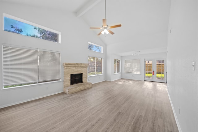 unfurnished living room featuring ceiling fan, high vaulted ceiling, light hardwood / wood-style floors, and a brick fireplace