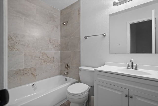 full bathroom with vanity, tiled shower / bath combo, and toilet