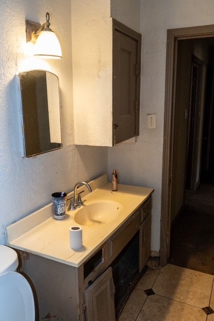 bathroom featuring tile patterned flooring, vanity, and toilet