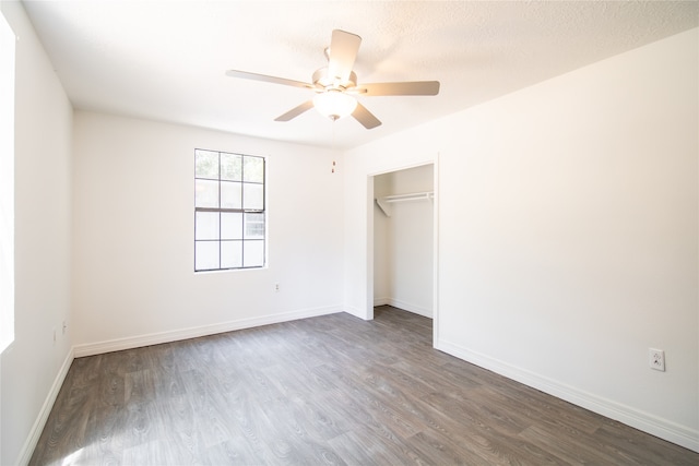 unfurnished bedroom with a closet, ceiling fan, dark hardwood / wood-style flooring, and a textured ceiling