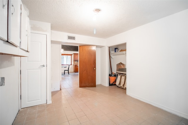 unfurnished room with light tile patterned floors and a textured ceiling