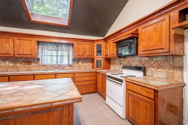 kitchen with backsplash, sink, tile countertops, white electric stove, and lofted ceiling