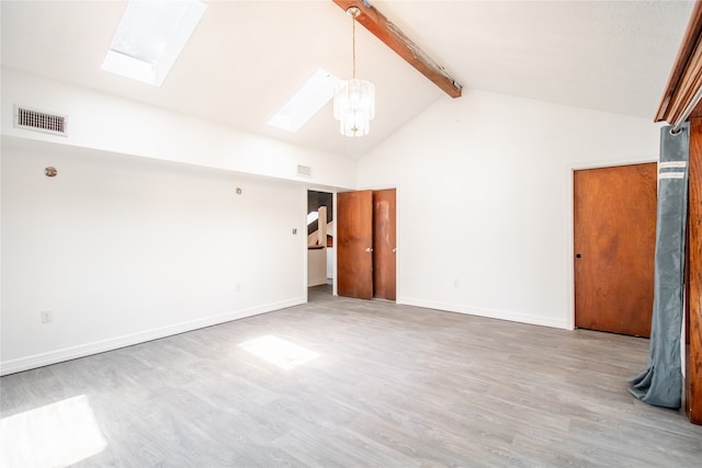 empty room with beamed ceiling, wood-type flooring, a skylight, and high vaulted ceiling