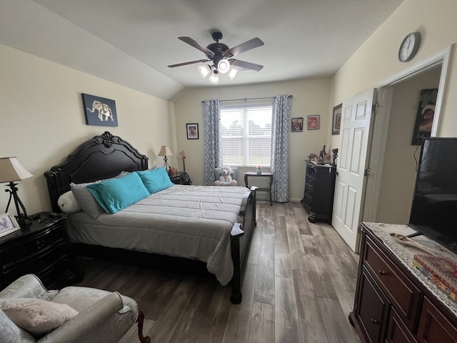 bedroom with ceiling fan, wood-type flooring, and lofted ceiling