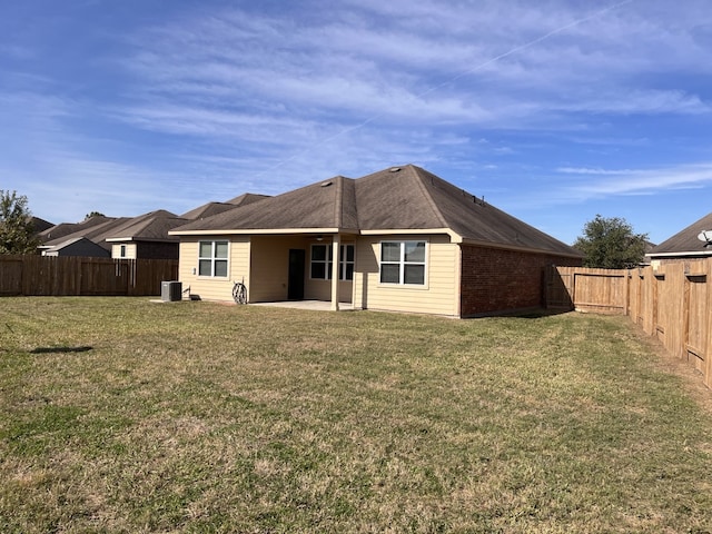 rear view of house featuring a yard, central AC unit, and a patio area