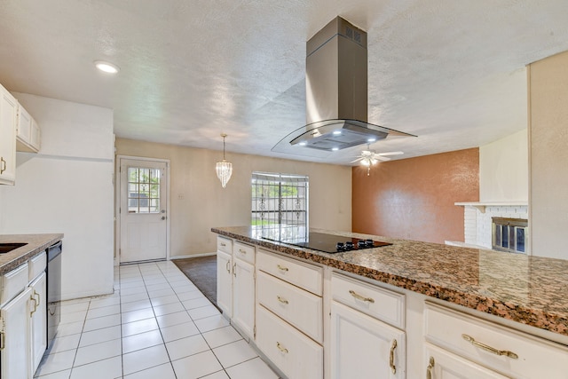 kitchen featuring island exhaust hood, black appliances, decorative light fixtures, dark stone countertops, and white cabinetry