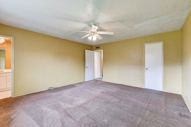 spare room featuring ceiling fan, carpet, and a textured ceiling