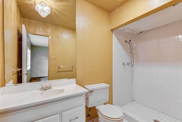 bathroom featuring vanity, toilet, and tiled shower