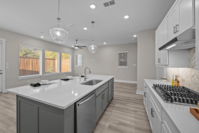 16034 Mason Run Dr, Houston, TX 77079 - kitchen with stainless steel appliances, under cabinet range hood, recessed lighting, light countertops, and light wood-type flooring