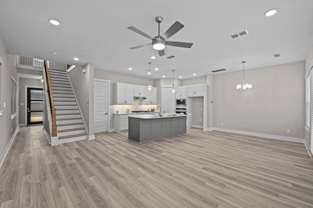 16034 Mason Run Dr, Houston, TX 77079 - kitchen with a chandelier, a ceiling fan, recessed lighting, light wood finished floors, and a kitchen island with sink