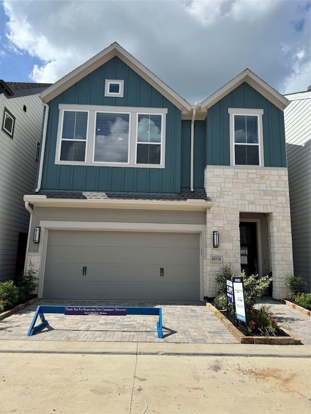 16034 Mason Run Dr, Houston, TX 77079 - view of front of house featuring board and batten siding, stone siding, an attached garage, and driveway