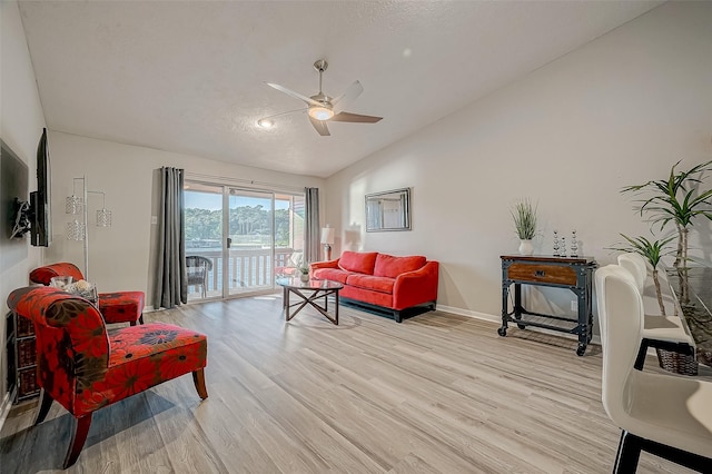 living room with lofted ceiling, a textured ceiling, ceiling fan, and light hardwood / wood-style flooring