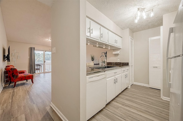 kitchen with sink, white appliances, light hardwood / wood-style floors, and white cabinets