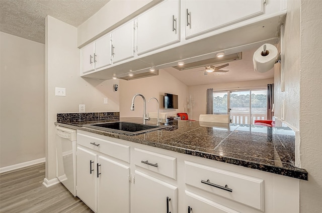 kitchen with white cabinetry, dishwasher, sink, ceiling fan, and light hardwood / wood-style floors