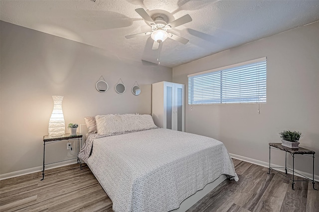 bedroom featuring hardwood / wood-style flooring, a textured ceiling, and ceiling fan