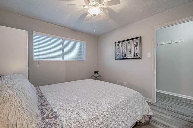 bedroom featuring hardwood / wood-style flooring, ceiling fan, and a textured ceiling