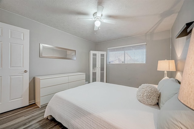 bedroom featuring a textured ceiling, light hardwood / wood-style floors, and ceiling fan