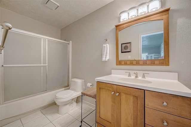 full bathroom with tile patterned floors, toilet, shower / bath combination with glass door, a textured ceiling, and vanity