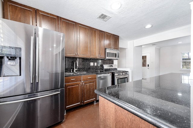 kitchen with sink, backsplash, dark stone countertops, appliances with stainless steel finishes, and ornamental molding