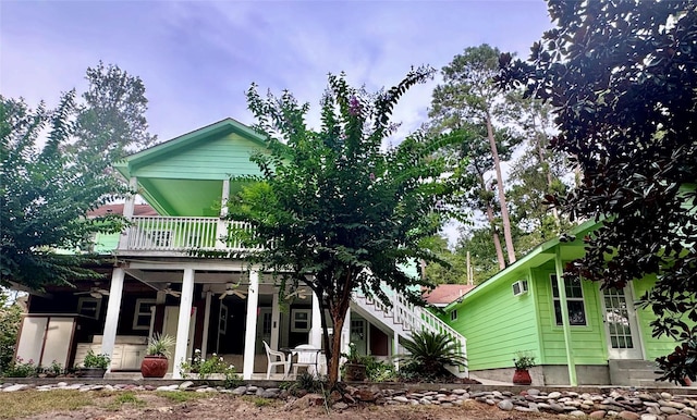 rear view of property with a balcony and covered porch