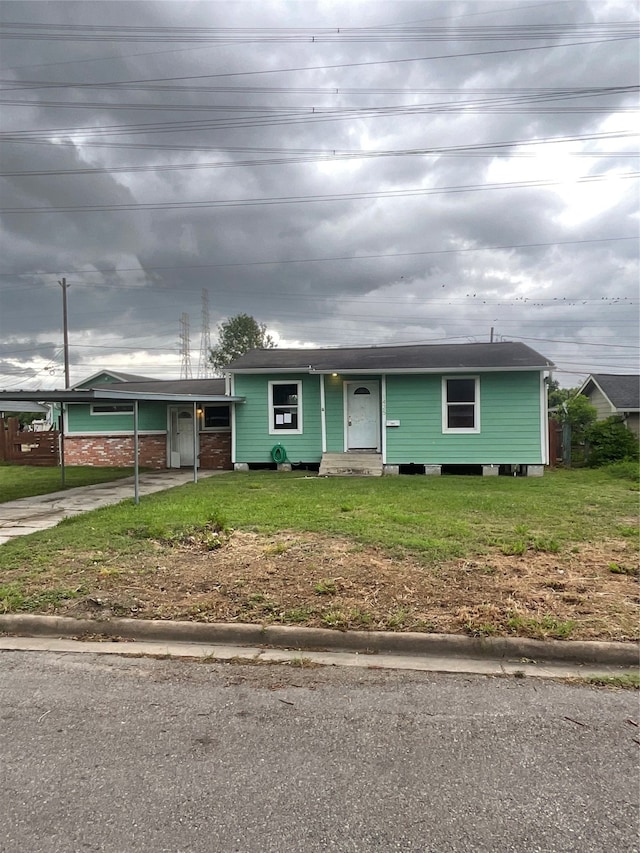 view of front of house with a front lawn and a carport