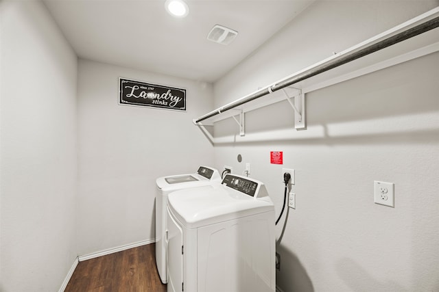 laundry area with washer and clothes dryer and dark wood-type flooring