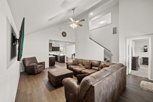 living room with ceiling fan, high vaulted ceiling, and dark wood-type flooring