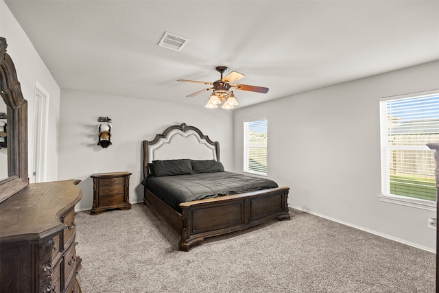 bedroom featuring light colored carpet, multiple windows, and ceiling fan