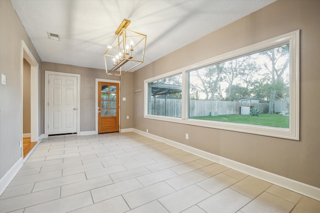 interior space featuring a textured ceiling and a chandelier