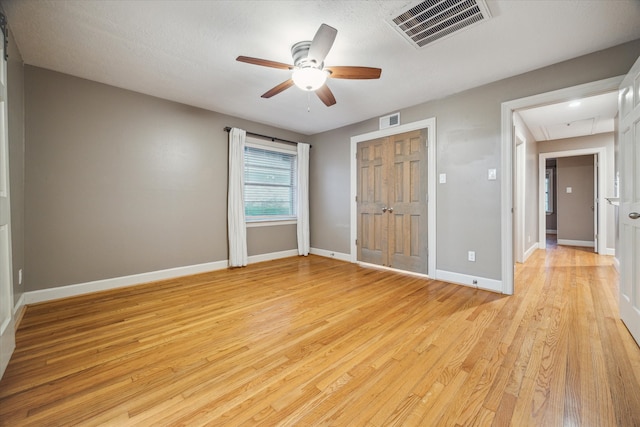 unfurnished bedroom with a textured ceiling, light wood-type flooring, and ceiling fan