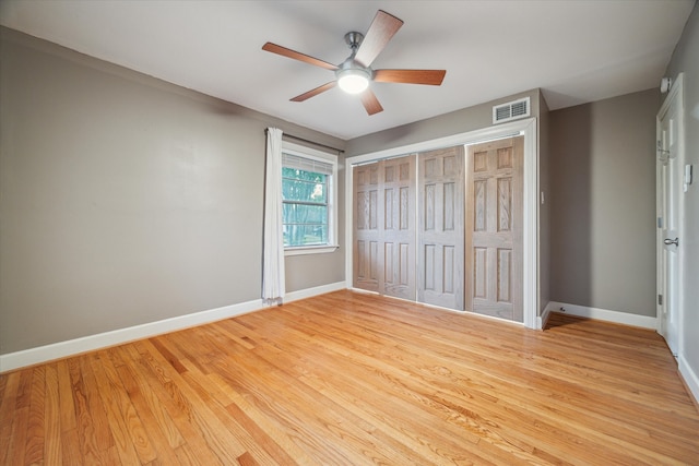 unfurnished bedroom featuring a closet, light hardwood / wood-style flooring, and ceiling fan