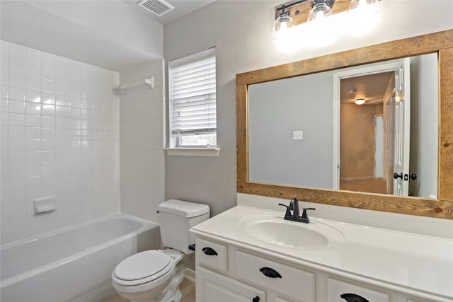 full bathroom featuring vanity, tiled shower / bath combo, and toilet