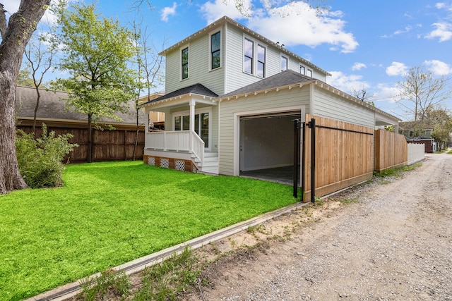 back of property with a yard and covered porch