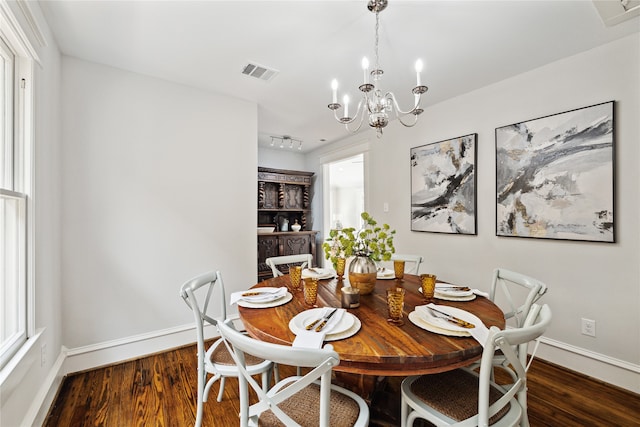 dining space featuring a notable chandelier and dark wood-type flooring