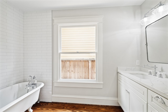 bathroom with vanity, a bath, and wood-type flooring