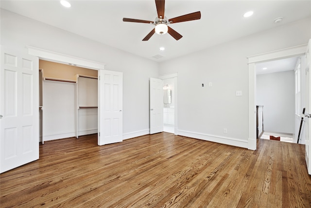 unfurnished bedroom featuring wood-type flooring, a closet, and ceiling fan