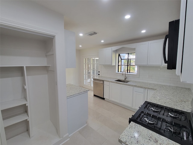 kitchen with light stone countertops, sink, white cabinetry, and black appliances