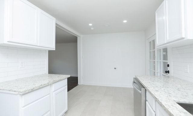 kitchen with dishwasher, decorative backsplash, white cabinetry, and light stone countertops