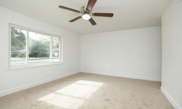 spare room featuring light carpet and ceiling fan