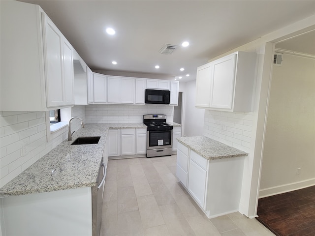 kitchen with sink, light stone countertops, white cabinetry, and stainless steel appliances