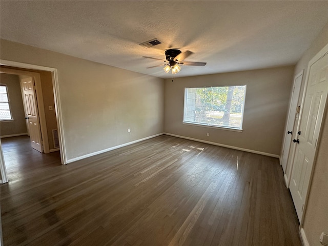 spare room with a textured ceiling, dark hardwood / wood-style floors, and ceiling fan