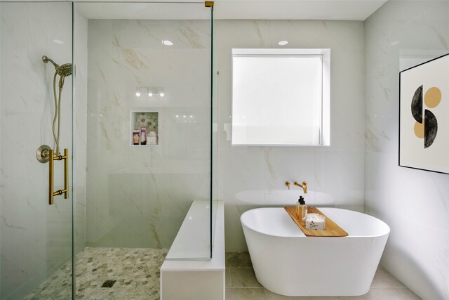 bathroom featuring tile walls and shower with separate bathtub